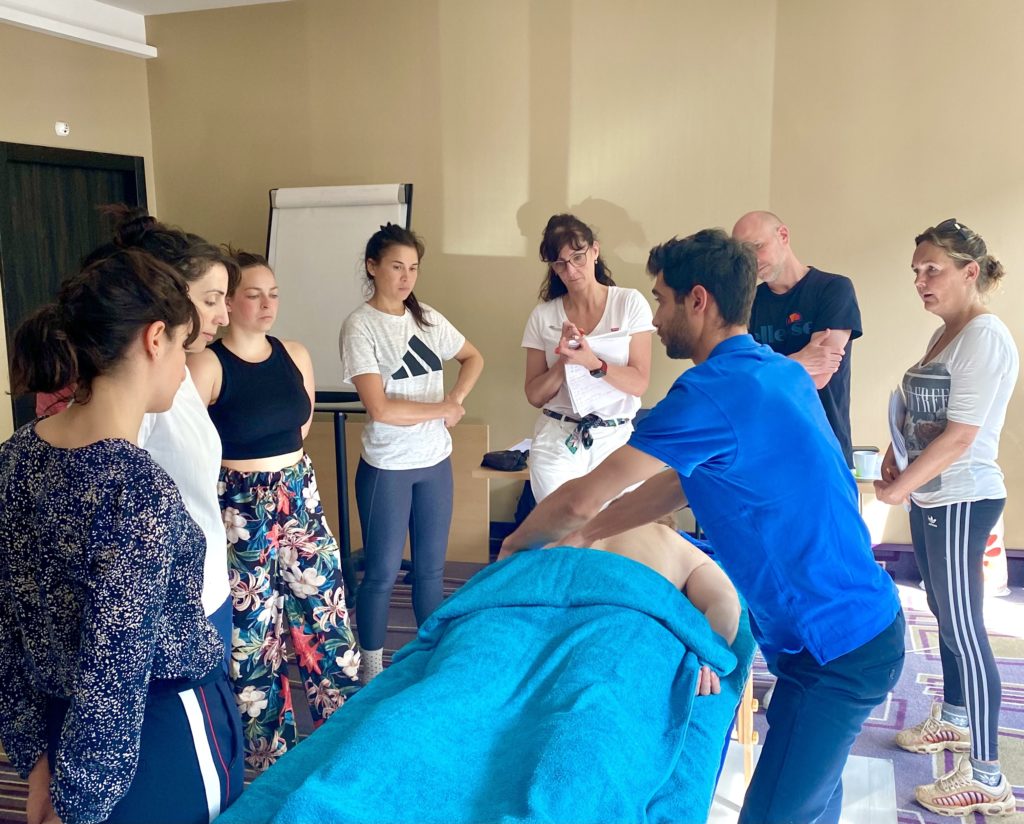 Formateur Colibri Massage Academy corrigeant le geste d'une élève